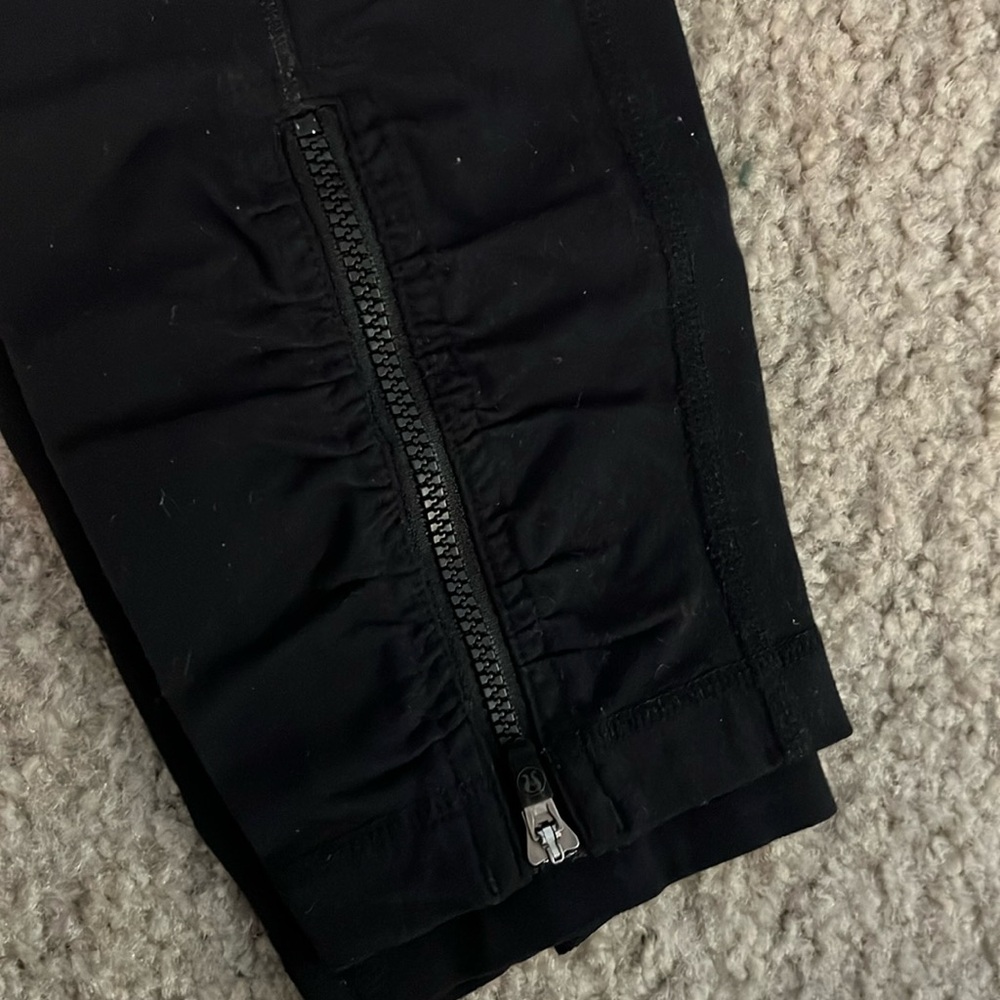Lululemon black crop leggings with zipper and scrunch detail.
